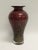 A striking tall oxblood red and gold art glass vase (10.5"). The heavyweight vase has a unique gold drizzle with a clear...