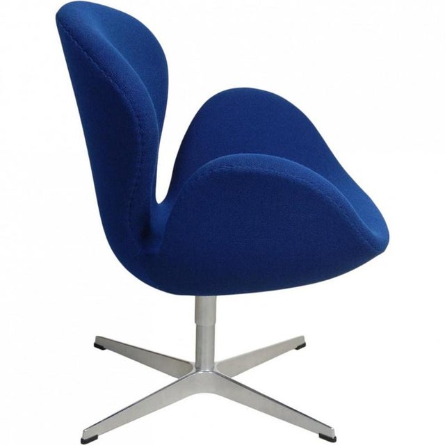 Arne Jacobsen Swan chair upholstered in original blue fabric, and with a brushed aluminium swivel base. The chair is from...