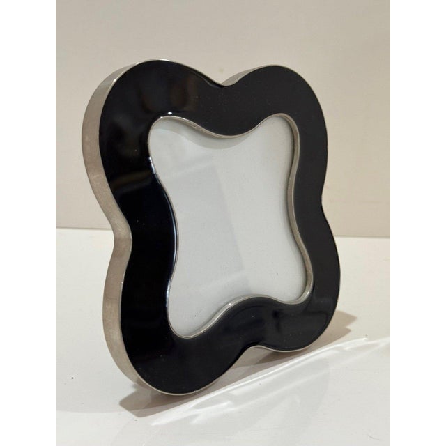 A chic Jonathan Adler clover-shaped picture frame in glossy black enamel with polished silver-tone trim. This sculptural,...