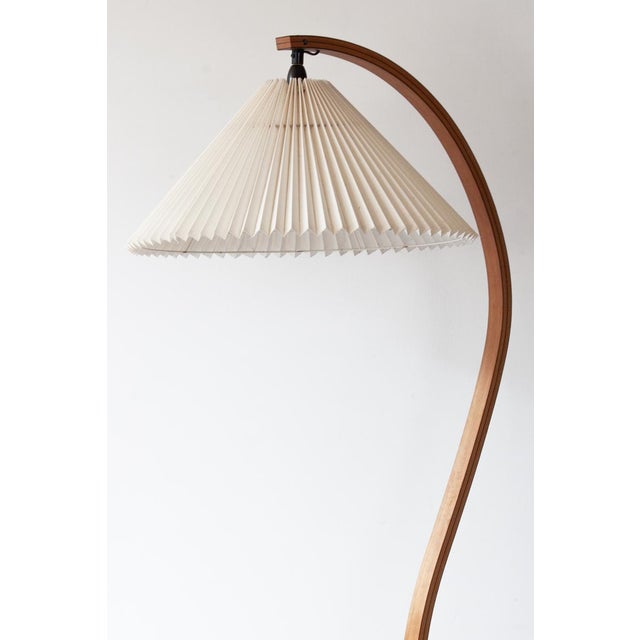 An original, vintage mads caprani floor lamp, crafted in denmark in the 1970s featuring a curved bentwood stem in solid...