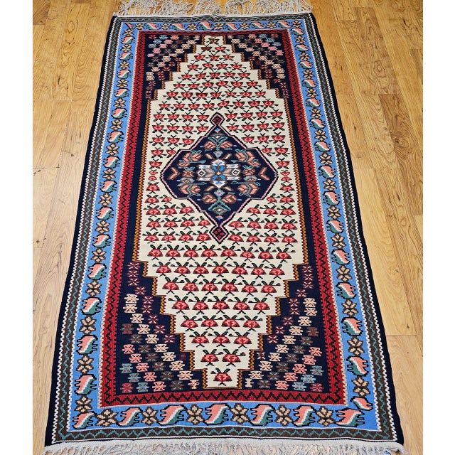 "A beautiful vintage Persian Senneh kilim area rug from the Kurdistan region of Western Persia, featuring a striking...