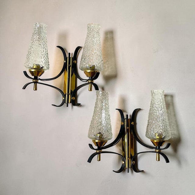 Striking vintage double wall sconce featuring two sculptural, textured clear glass shades set within an elegant...