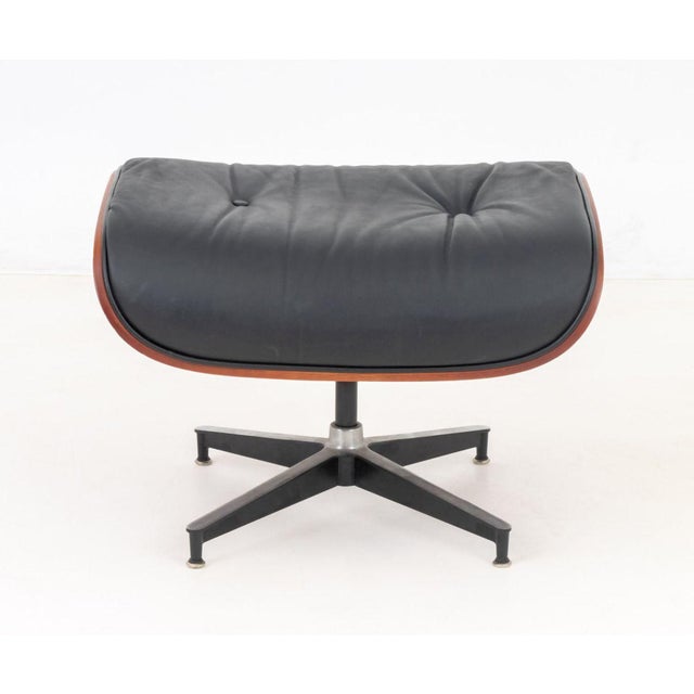 Eames Style Bentwood Footstool, with black leather upholstery on patinated metal base.1 7.25" H x 24.25" W x 21" D....