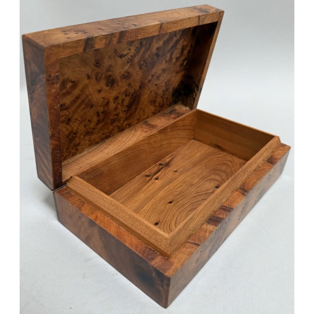 A richly figured vintage Moroccan wooden box crafted circa 1900, showcasing the natural splendor of amboyna burl. This...