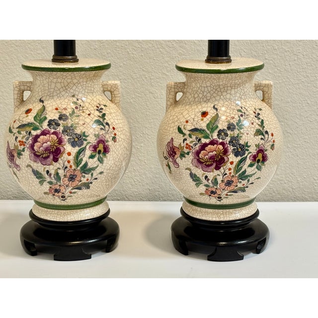 Beautiful purple and dusty pink florals on a background of crackled ivory make this pair of table lamps an eye catching...