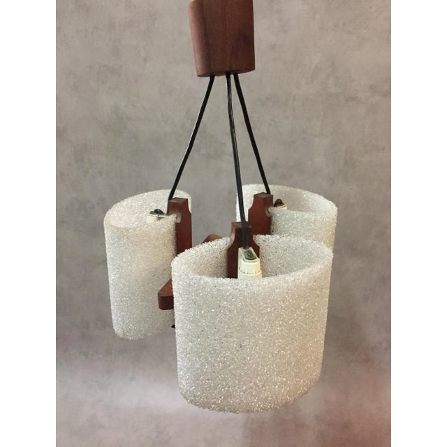 This vintage Scandinavian teak pendant lamp features three acrylic glass and resin bulb holders. European Plug (up to...