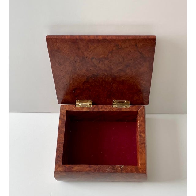 Beautiful lidded burl wood box. The box has a felt lining and measures about 4” x 5” x 2” high.