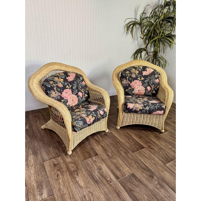 Beautifully shaped vintage wicker lounge chairs with cushions. The woven wicker detailing and floral cushions create an...