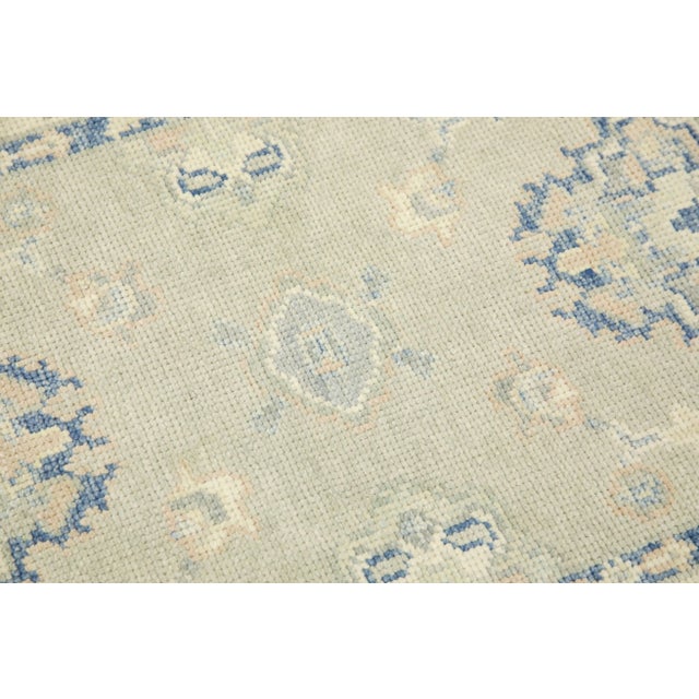 This modern Turkish Oushak rug is a stunning piece of art that has been handwoven using traditional techniques by skilled...