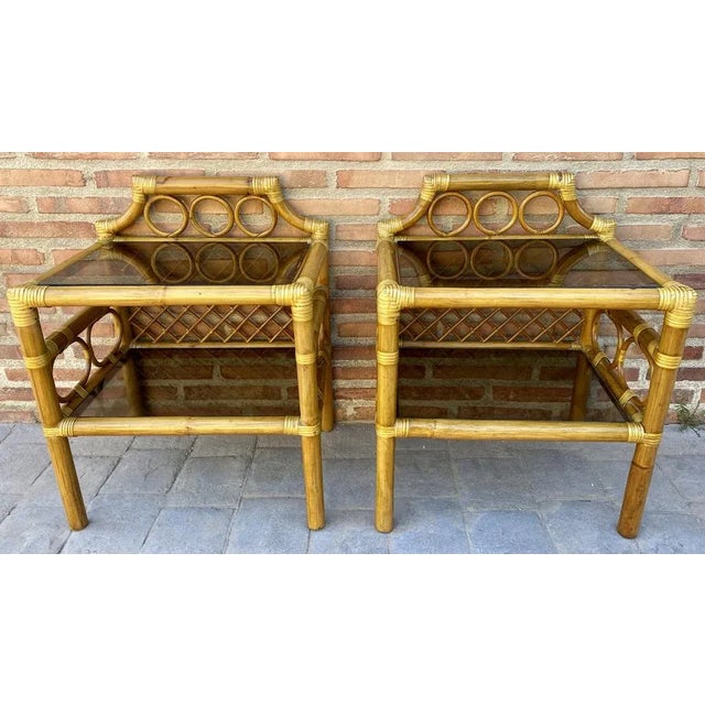 Pair of mid-century rattan and bamboo nightstands with glass base and glass low shelf. Rattan streamlined side nightstand...