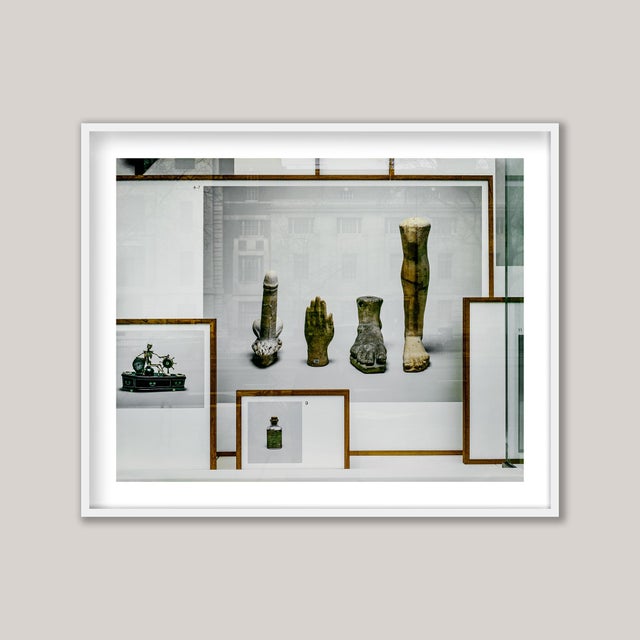 In the window of a museum in central London, a selection of objects photographed are displayed to the street beyond. The...