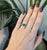 A 0.98ct zambian emerald oval ring set in solid 14K white gold, set with fifty earth mined diamonds and eight blue...