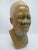 African hand carved bust made from a variegated stone showing detailed facial features and hair. Measures 9 1/2" tall x 3...