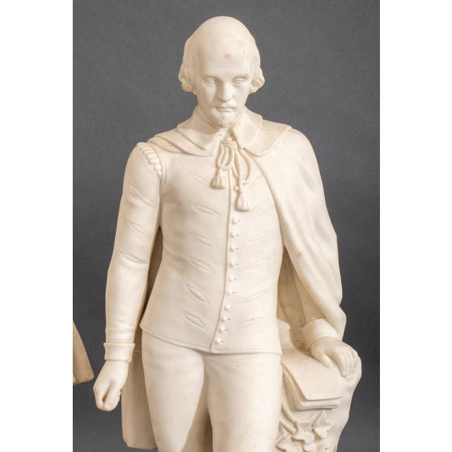 Two Parian Ware William Shakespeare Sculptures, circa 19th century, one figure standing beside an ivy-covered tree stump...