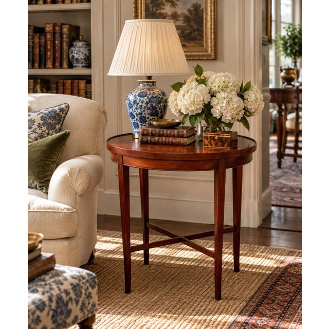 A beautifully proportioned circa 1930s–40s mahogany side table with an elegant oval top, subtly raised edge, and slender...