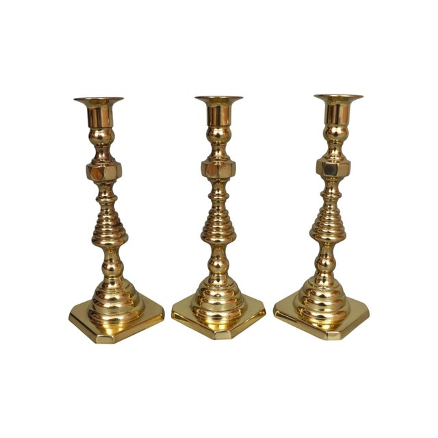 A set of three traditional brass candlestick holders made in the USA by Baldwin Brass. Turned with beehive shaped columns...