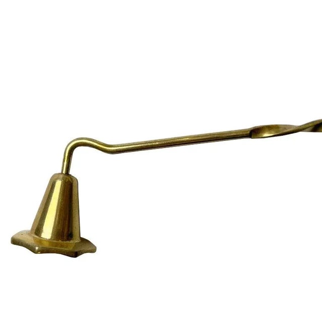 A long brass candle snuffer, made in India. Created from brass, this long candle snuffer will be a beautiful accent on any...