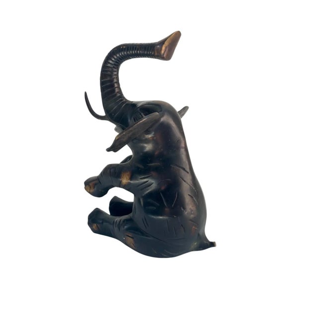 Large heavy Solid brass elephant with unique bronze finish in sitting position with elephants trunk positioned upwards,...