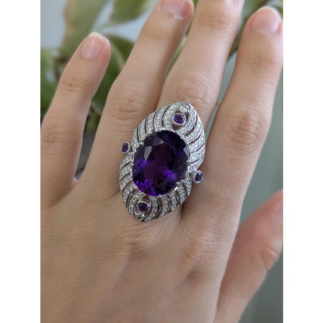 This striking ring features a large 20x15mm oval amethyst, set in solid 14K white gold and accented with natural, earth-...