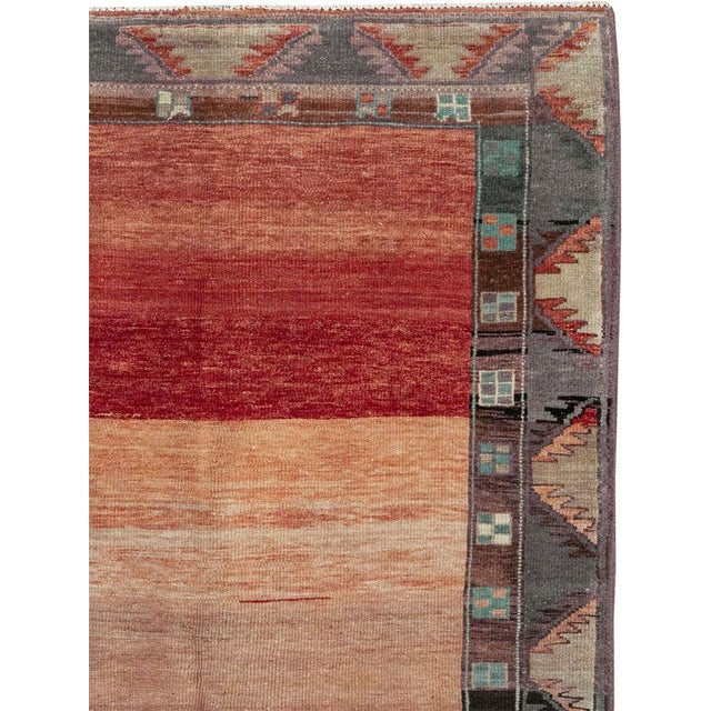 This mid-20th-century Turkish Anatolian wide gallery runner presents an expansive open field in layered tones of coral,...