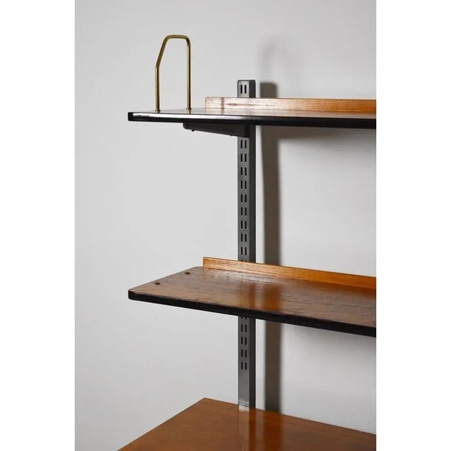 Teak wall shelf made in Sweden during 1960s. Made of teak and painted metal.