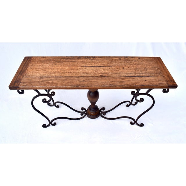 An impressive studio forged iron console table with solid Oak breadboard top, turned inlay vase shape center, distinctly...