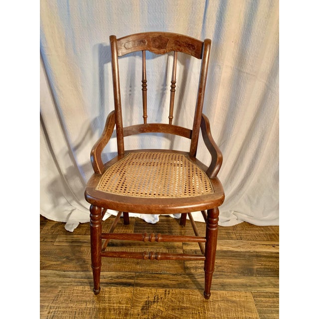 This Early 20th Century chair was crafted in France from walnut with a cane seat in the early 1900's. The chair features a...