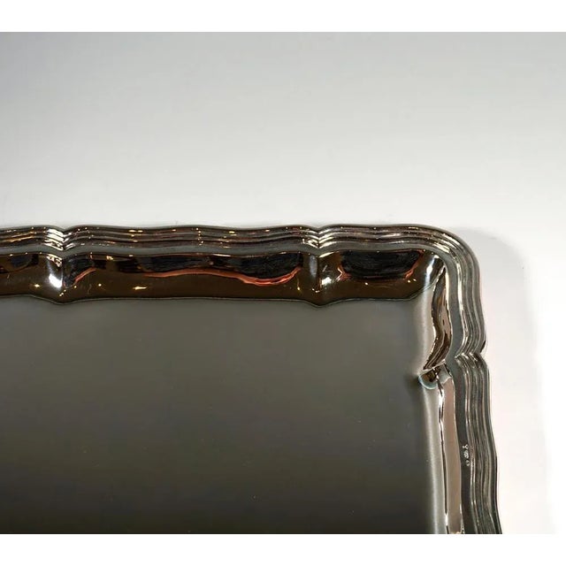 Rectangular shaped silver plate in a smooth, simple design with a wavy, profiled edge. Engraving of the silversmith on the...