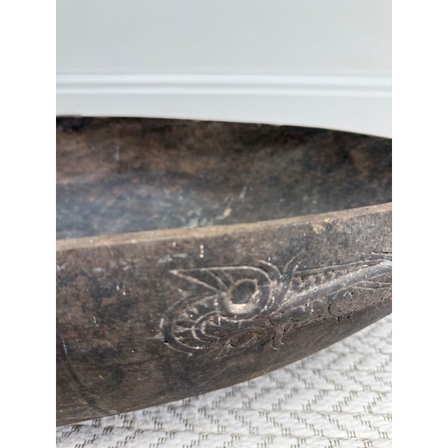 An exceptional feasting bowl, hand-carved from a single heavy block of hardwood The exterior flanks are adorned with...