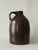 Hand-thrown stoneware jug in warm chocolate brown with natural glaze finish. Classic utilitarian form; functional handle;...