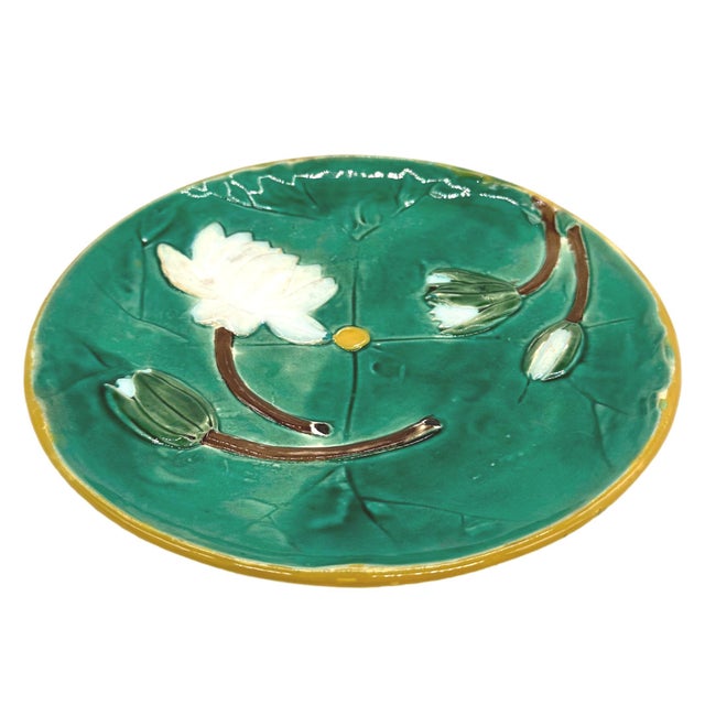 Joseph Holdcroft Majolica Pond Lily Plate, glazed in greens, and molded with flowering white lilies, with a yellow button...