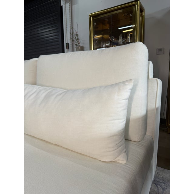 White fabric customer loveseat with a clean, modern look that brightens any living space. The piece features comfortable...