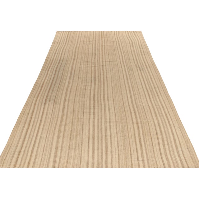 Handwoven in wool, a vintage kilim rug of the 1950s in panel style featuring a striped pattern playing warm and cool in...