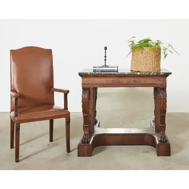 Handsome hall chair or armchair made in the English Georgian taste. The chair features a tall flat back with a humped...