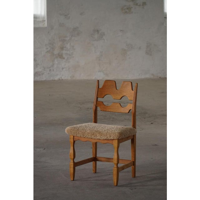 A beautiful and sculptural oak dining chair designed by Henning (Henry) Kjærnulf for Nyrup Møbelfabrik, Denmark, during...