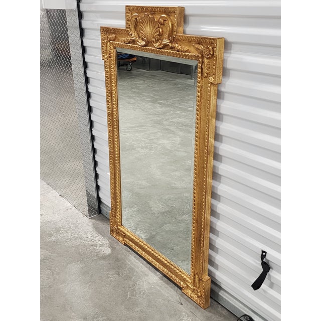 Vintage Italian Rococo style giltwood mirror with hand-carved shell crown motif and leaf accents. This exquisite mirror...