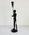 Vintage mid-20th-century folk art style taper candle holder featuring a stylized male form. Finished in satin black paint...