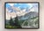 This artwork depicts a serene mountain landscape, where towering peaks rise majestically against a bright blue sky,...