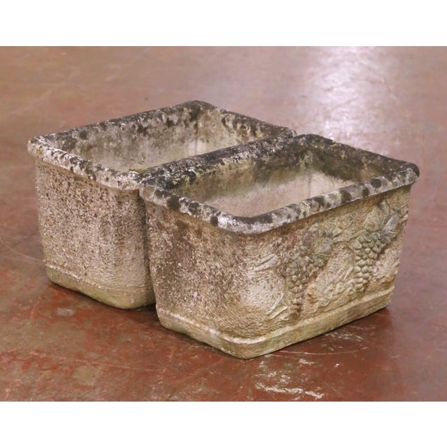 Crafted in France circa 1880, this handsome pair of antique cast stone jardinieres features a classic rectangular form...