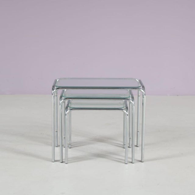 A beautiful set of three nesting tables, manufactured in the Netherlands in the 1970s. These elegant tables have tubular...