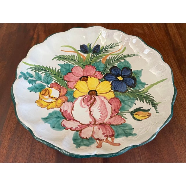 1960s ceramic folk art dish featuring a scalloped edge and a hand-painted botanical design of roses and wildflowers.
