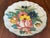 1960s ceramic folk art dish featuring a scalloped edge and a hand-painted botanical design of roses and wildflowers.
