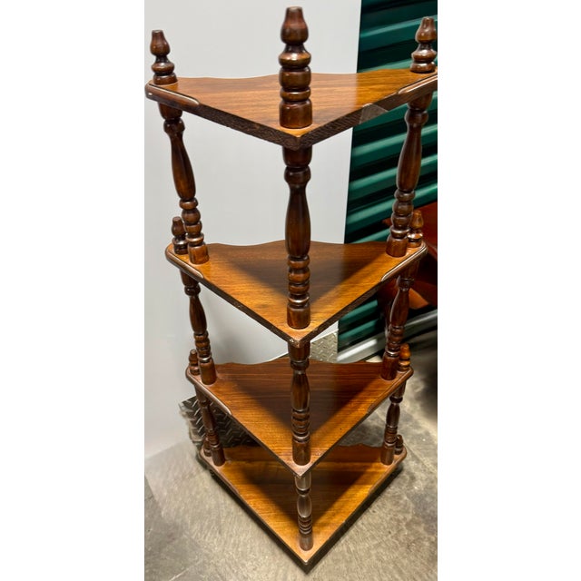 This wooden stand is characterized by its rich, dark-stained wood finish and turned pillar supports, common in mid-20th...