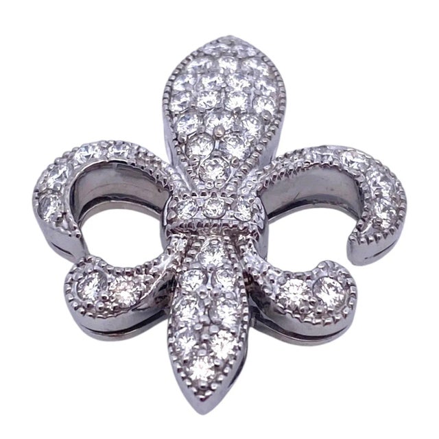 Crafted in 18K white gold, the slide pendant features a fleur-de-lis design adorned with pave' set diamonds. The piece...