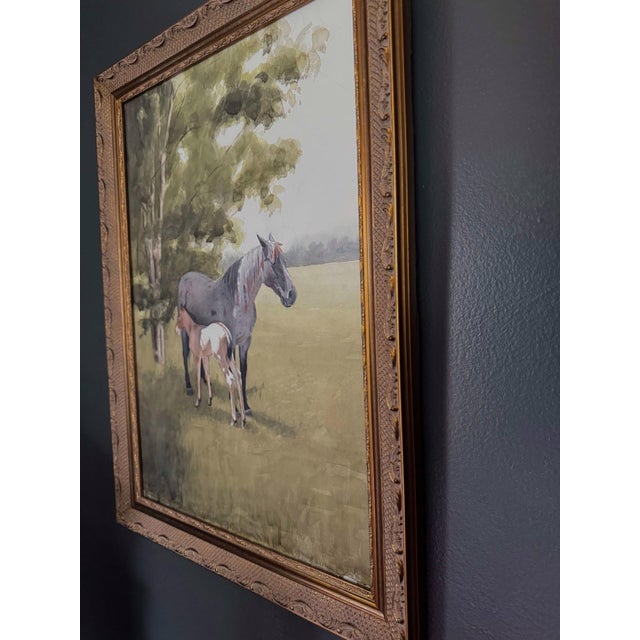 This watercolor depicts a serene moment between a mare and her foal, nestled beneath the gentle shade of trees. The soft,...