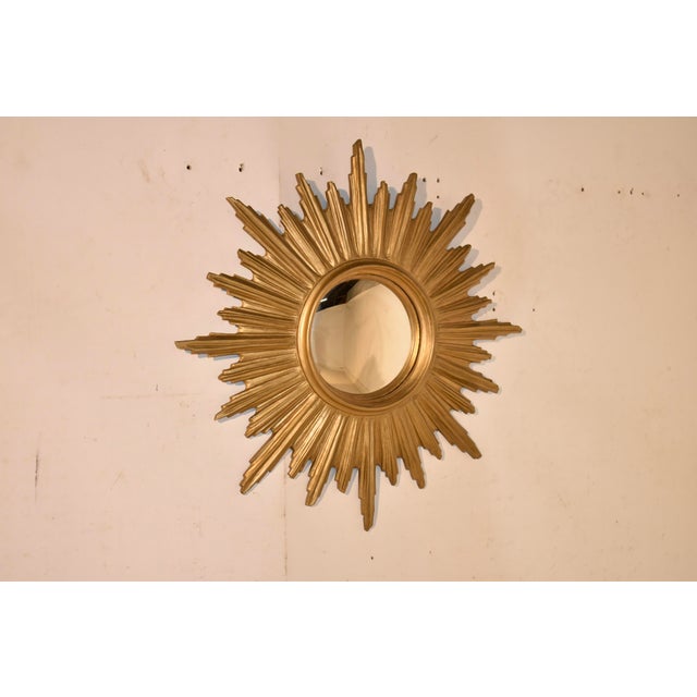Mid-century sunburst mirror from France. The mirror itself is convex in shape and is surrounded by a nicely molded edge...