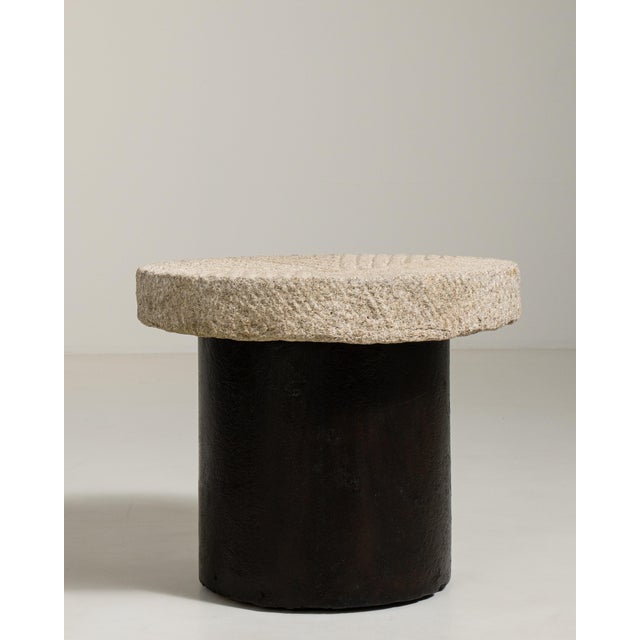 A substantial early 20th century side table with a heavier stone top and a robust wrought iron base, emphasising weight...