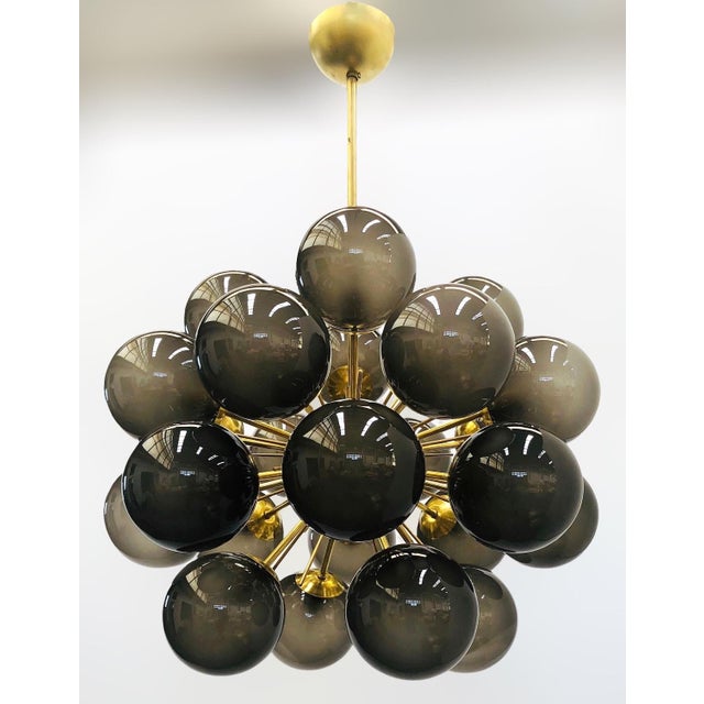 Italian sputnik chandelier with 24 frosted smoky Murano glass globes mounted on brass frame in unlacquered natural brass...
