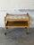 This two-tier serving cart features an open profile with gracefully raised corner handles. The upper surface showcases...