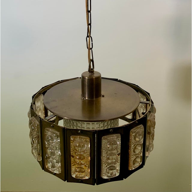 Discover this fantastic hanging lamp designed in the 60s and made in Denmark. The lamp is made of brass rings with a...
